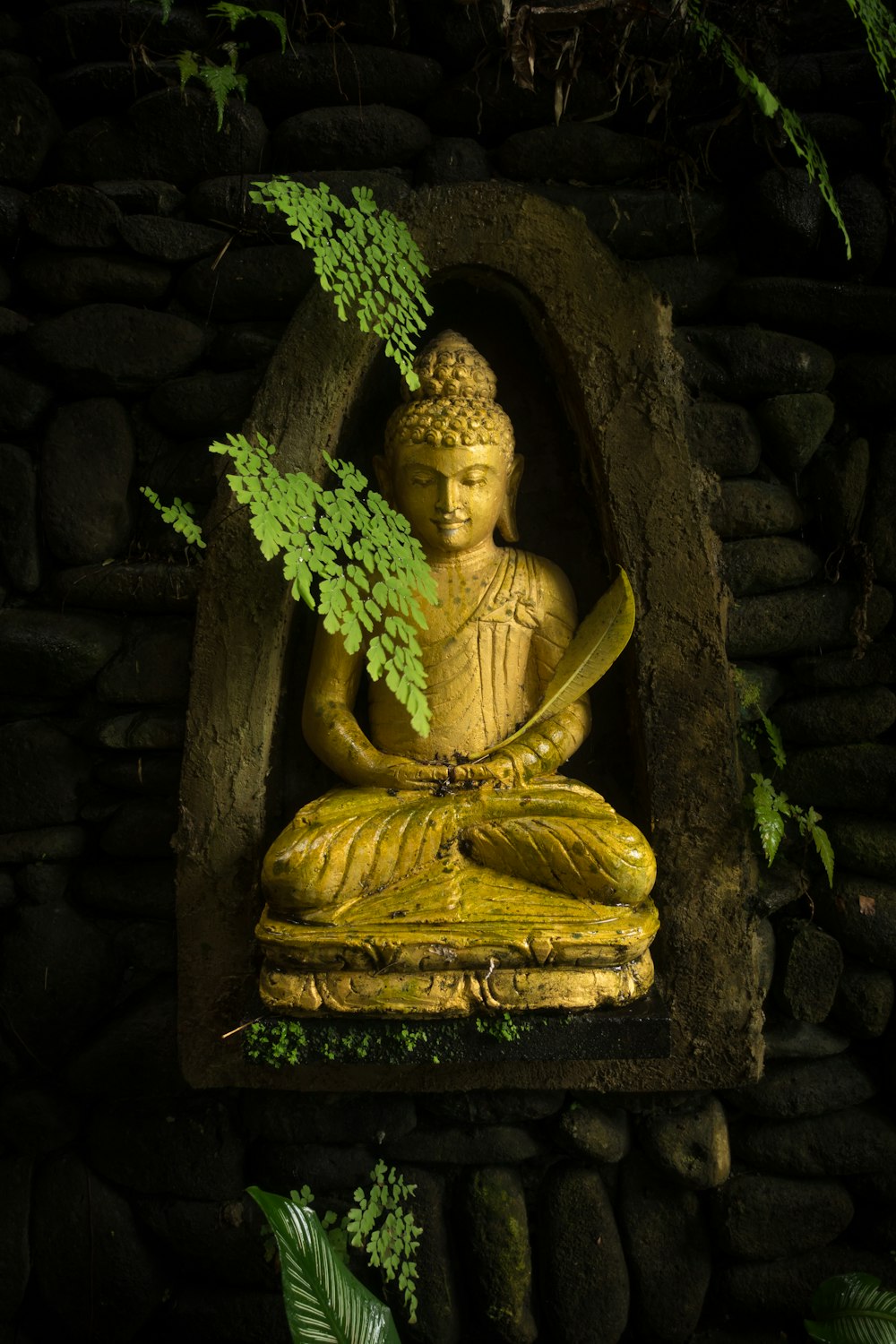 estátua de ouro de buddha na mesa de madeira marrom