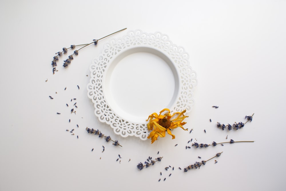 white and yellow flower petals on white ceramic plate
