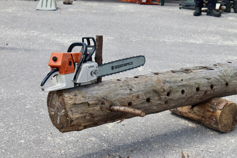 orange and white snow blower on brown wood log