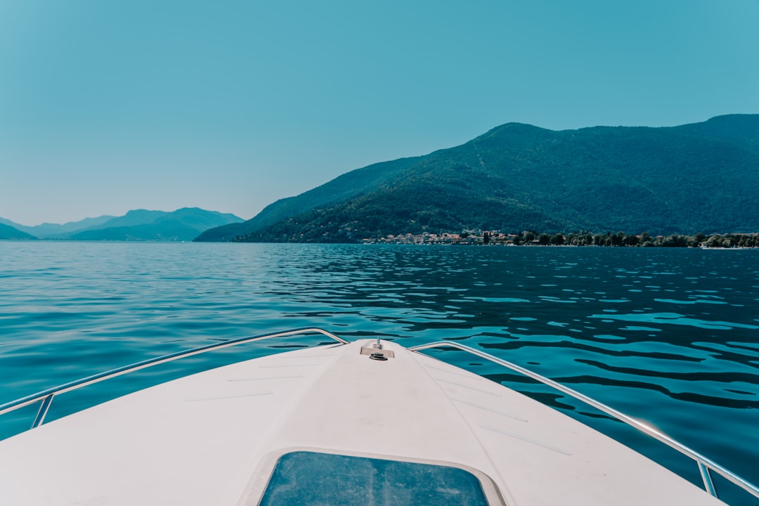 white boat on water near mountain during daytime