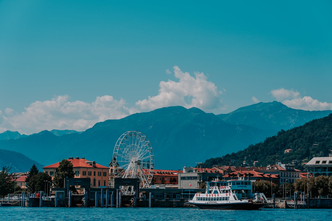 ferris wheel near buildings and mountain under blue sky during daytime