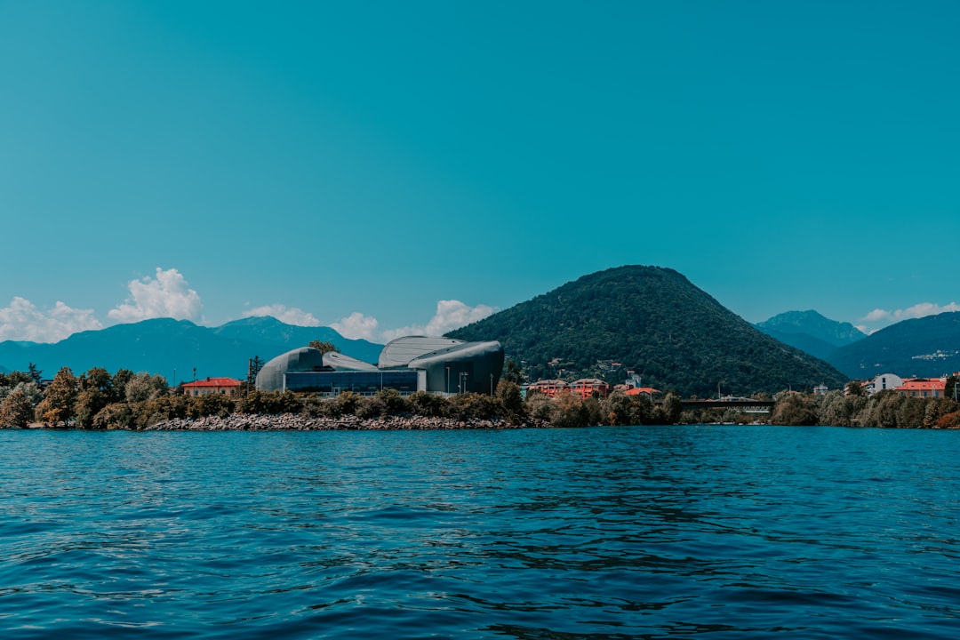 white and brown house near body of water under blue sky during daytime,