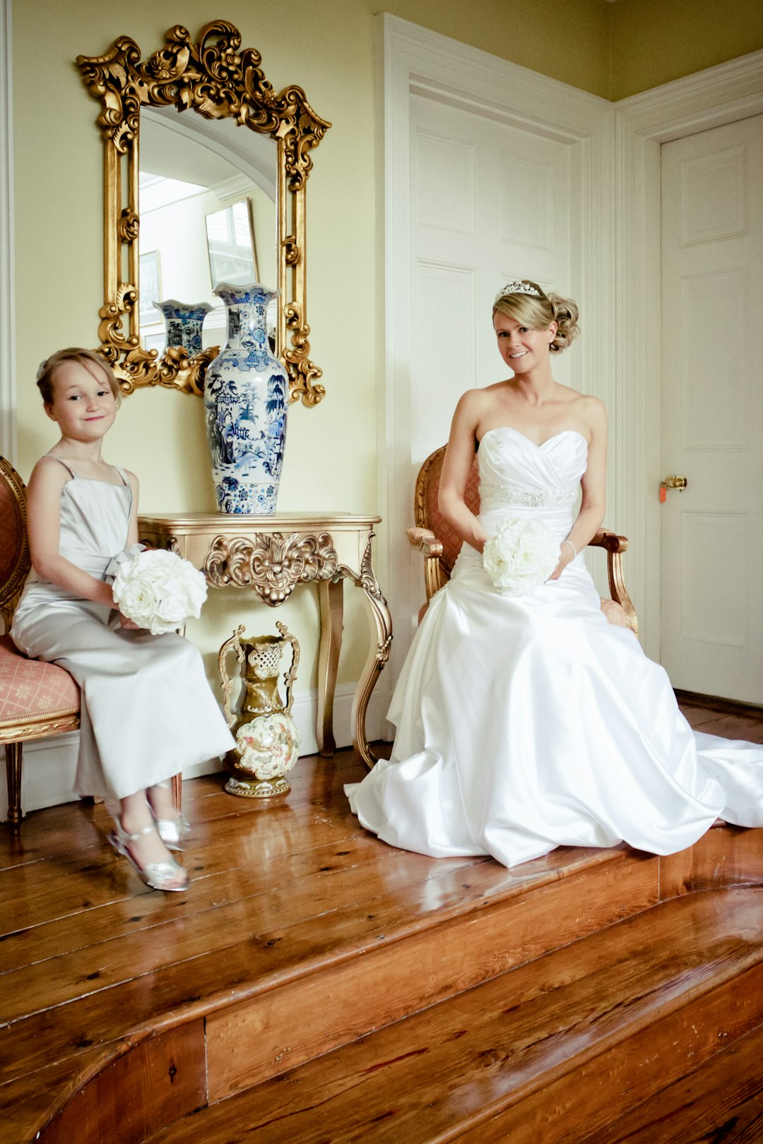 girl in white dress standing beside white floral chair