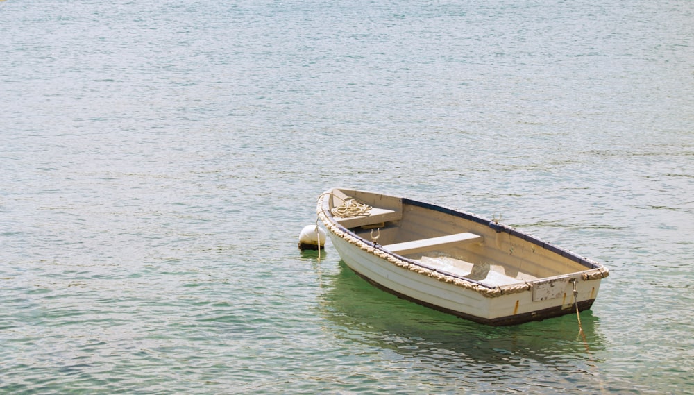 white and brown wooden boat on body of water during daytime