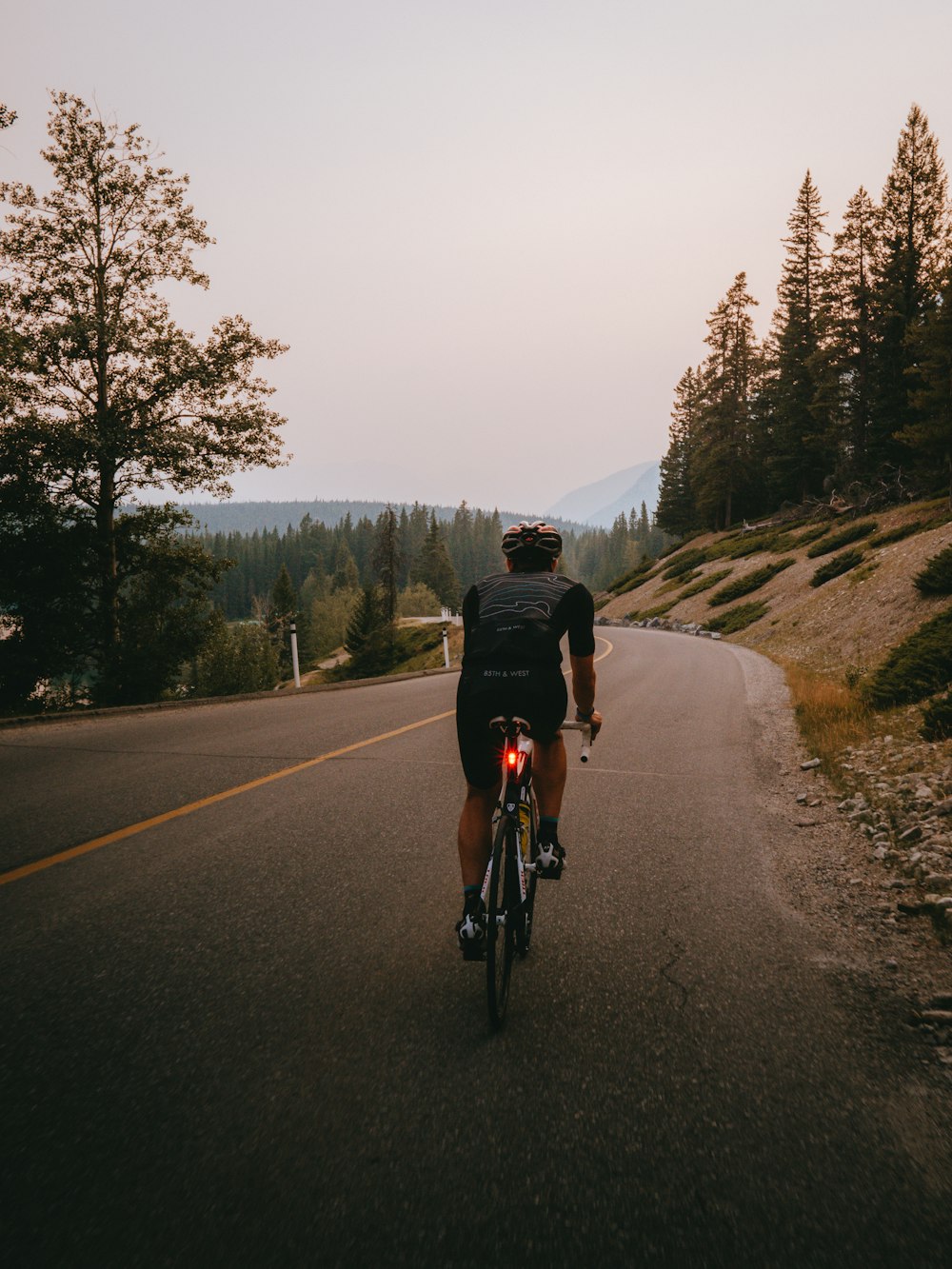 man in black jacket riding bicycle on road during daytime