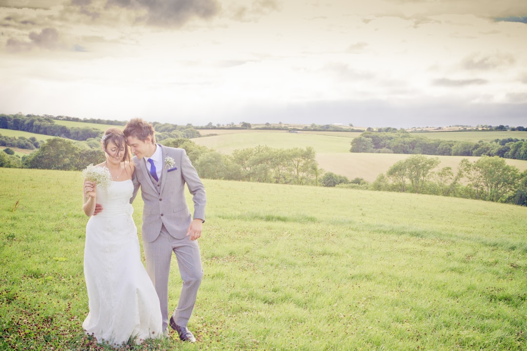 man and woman standing on green grass field during daytime