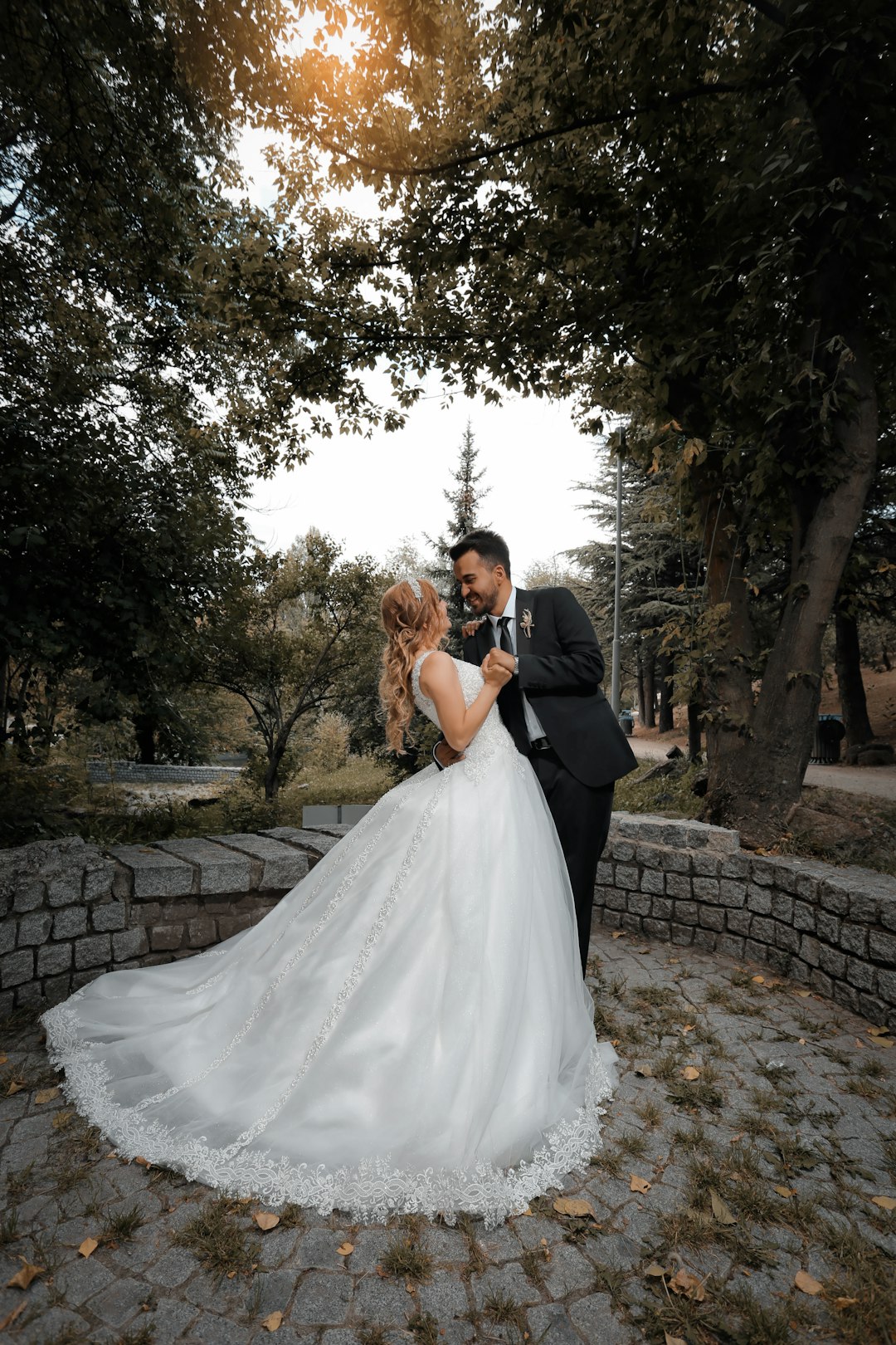 woman in white wedding gown kissing man in black suit