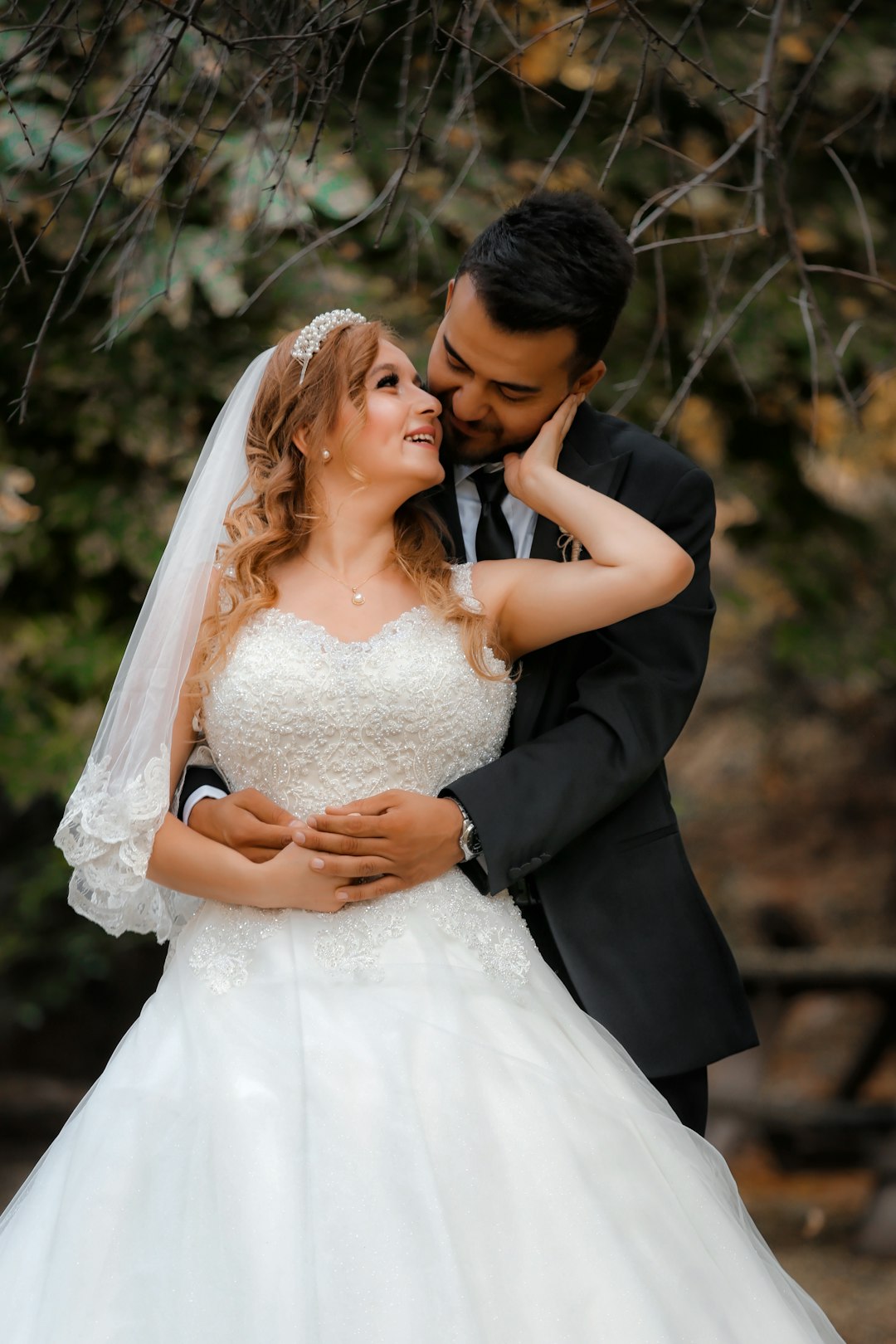 woman in white wedding dress kissing man in black suit