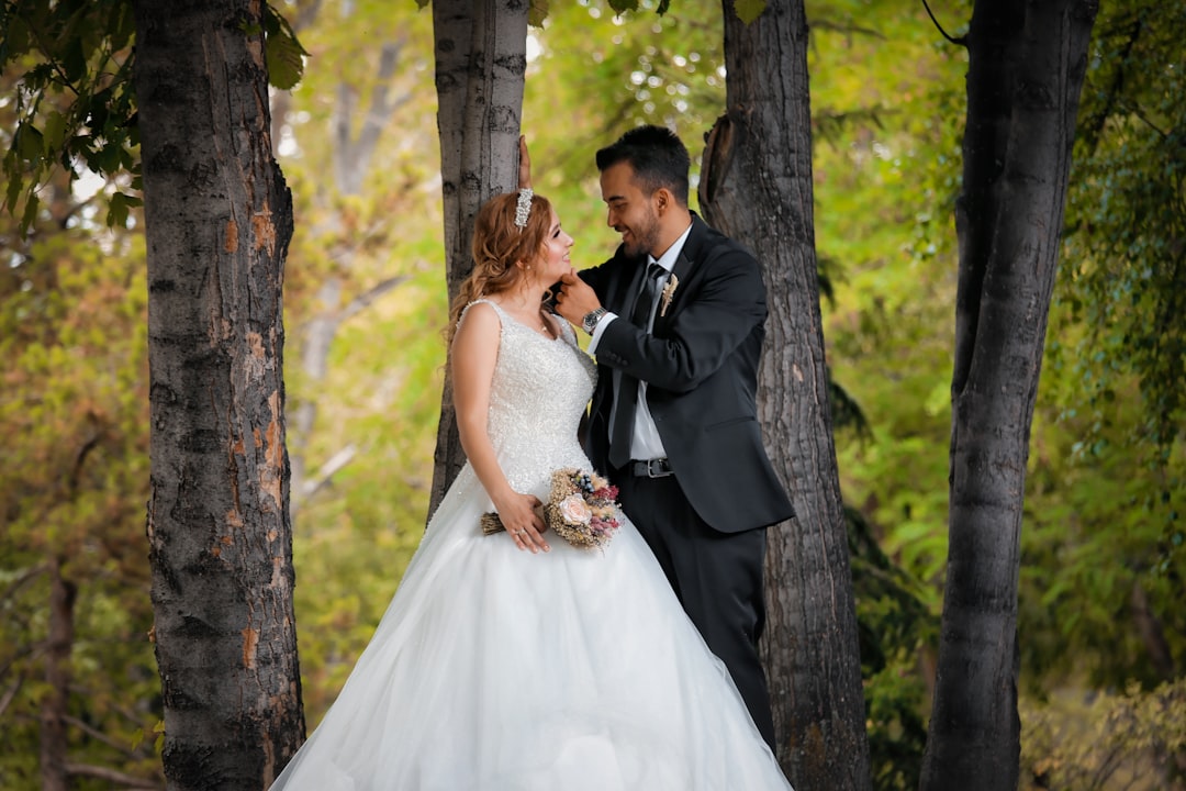 bride and groom kissing under tree