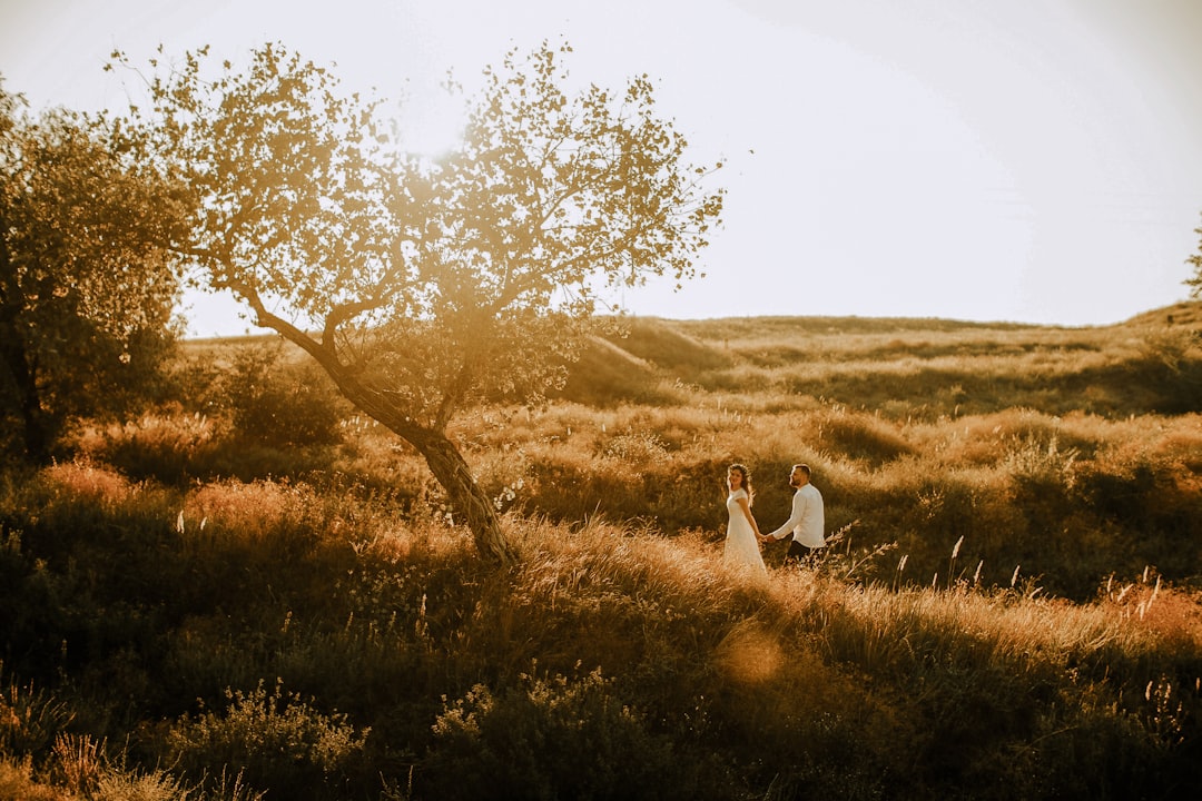 couple standing on green grass field during daytime