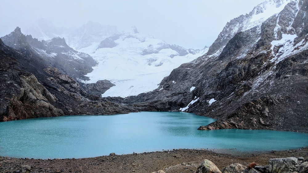 lake in the middle of mountains during daytime