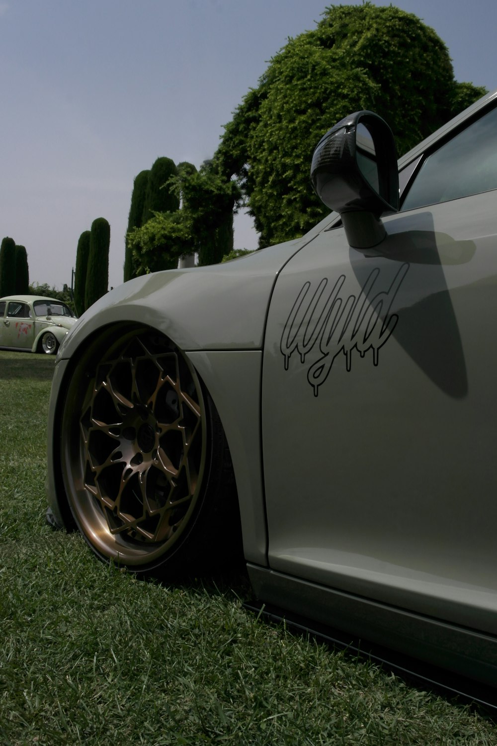 silver porsche 911 on green grass field during daytime