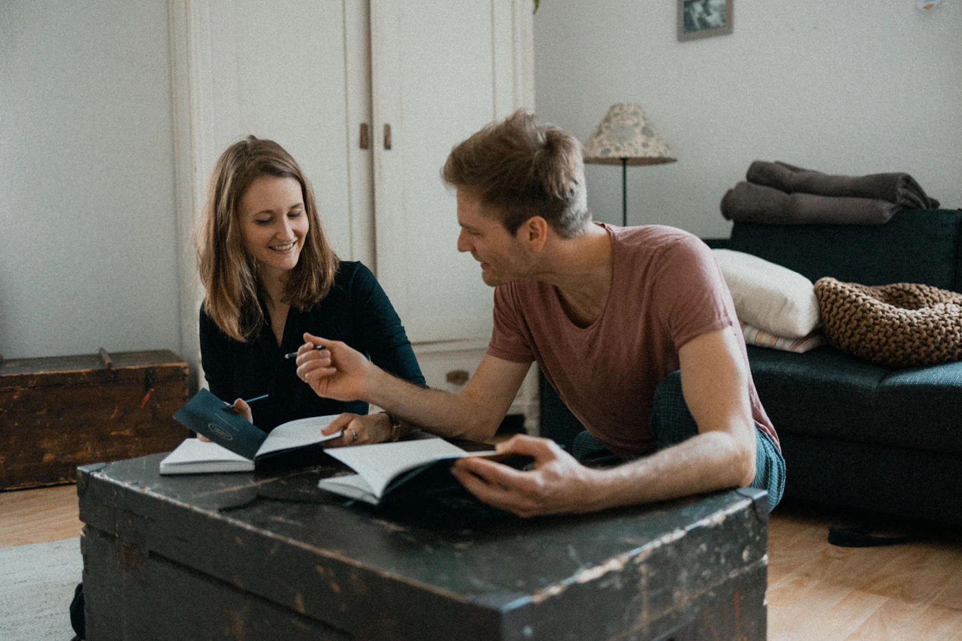 Couple smiling while reviewing notes together at home