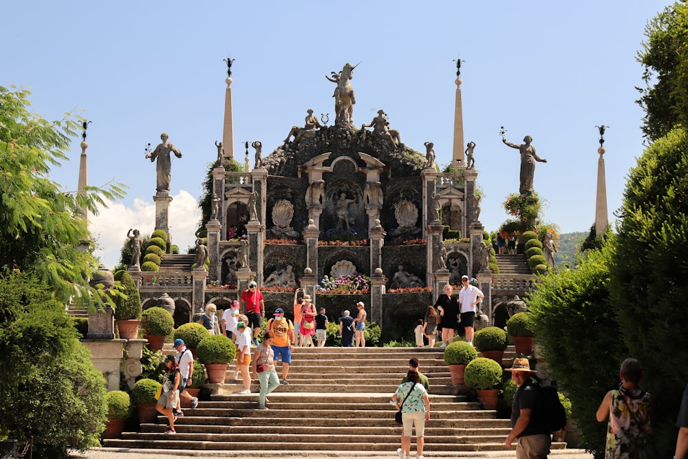 people walking on stairs near green trees during daytime