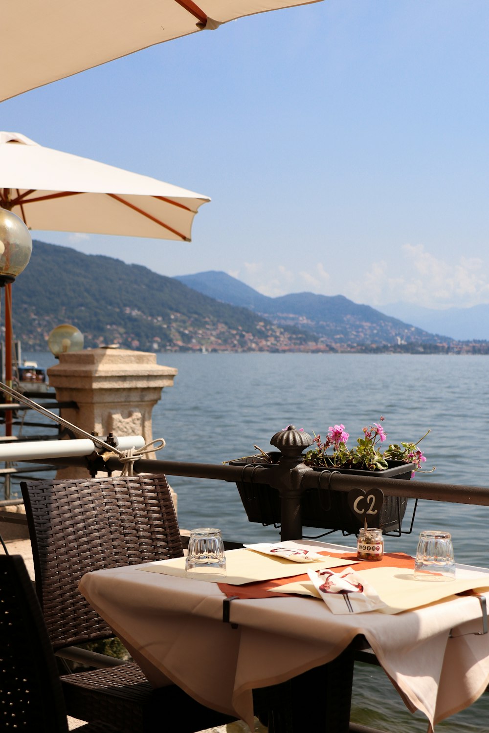 brown wooden table with chairs near body of water during daytime