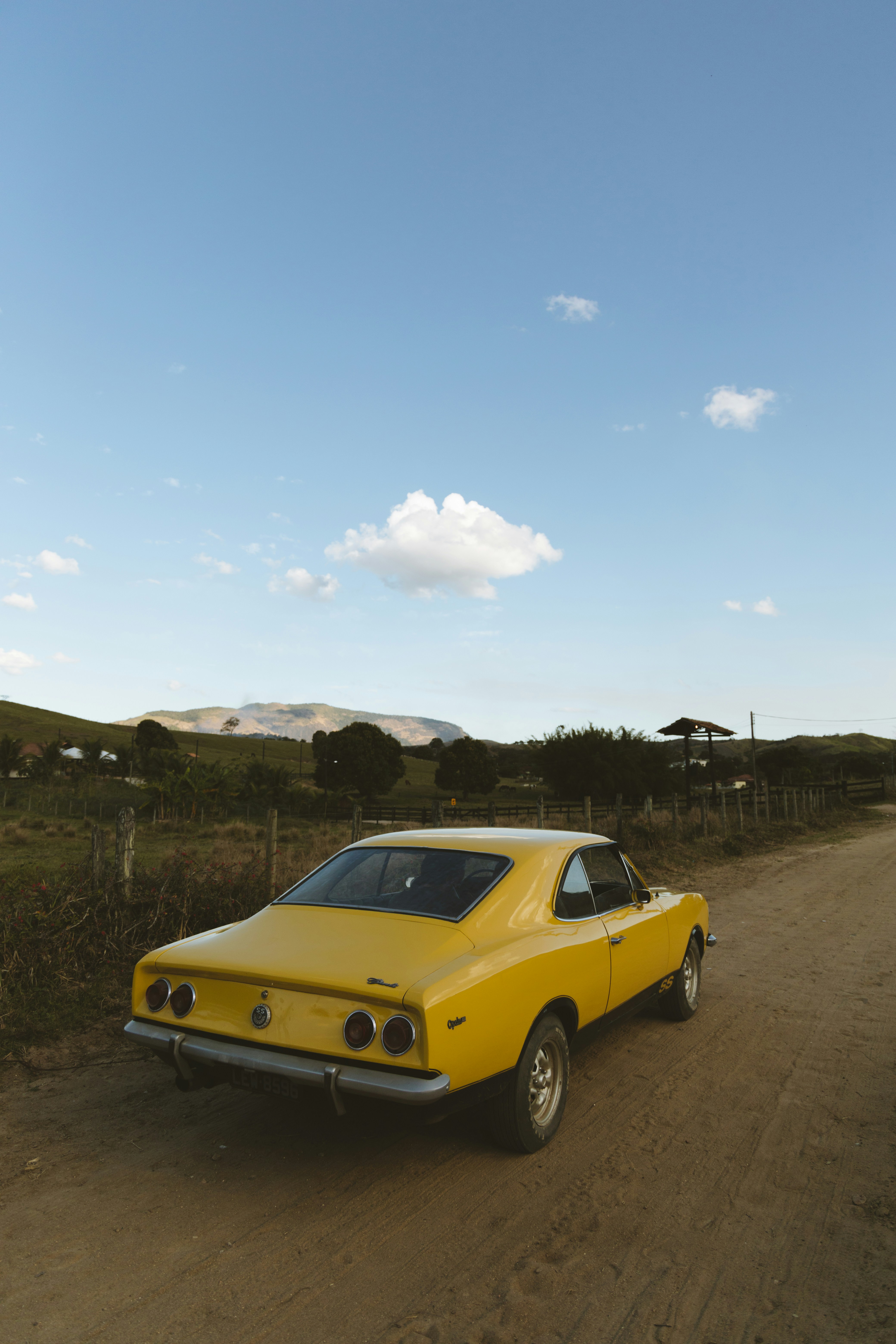 昼間の茶色の砂浜に黄色い車