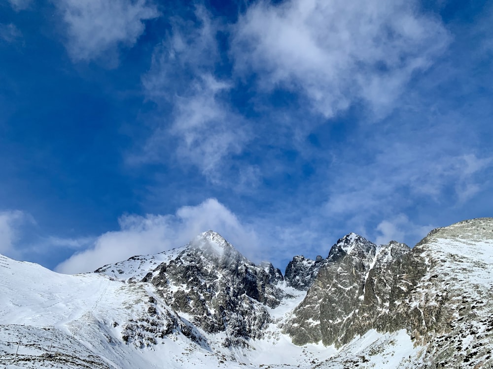 montanha coberta de neve sob o céu azul durante o dia