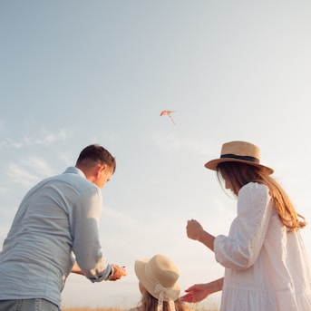 man and woman holding hands while walking on beach during daytime