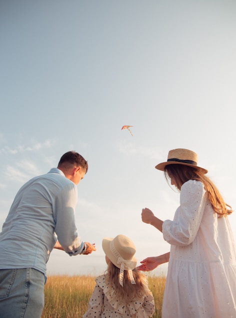 man and woman holding hands while walking on beach during daytime