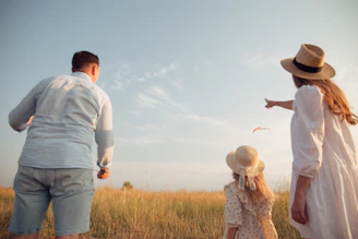 man in white dress shirt and woman in brown dress standing on green grass field during