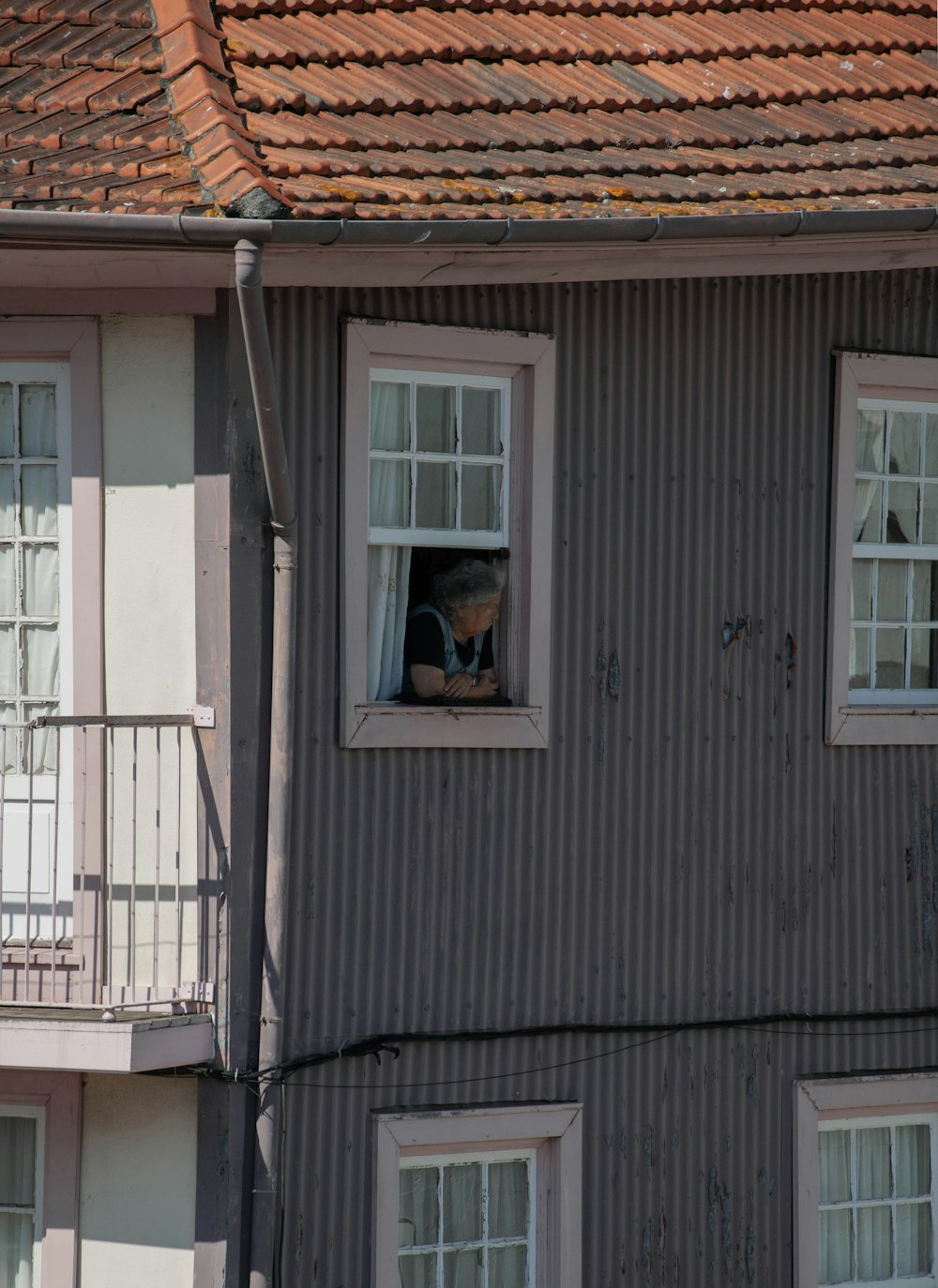 woman in black shirt standing in front of white wooden window