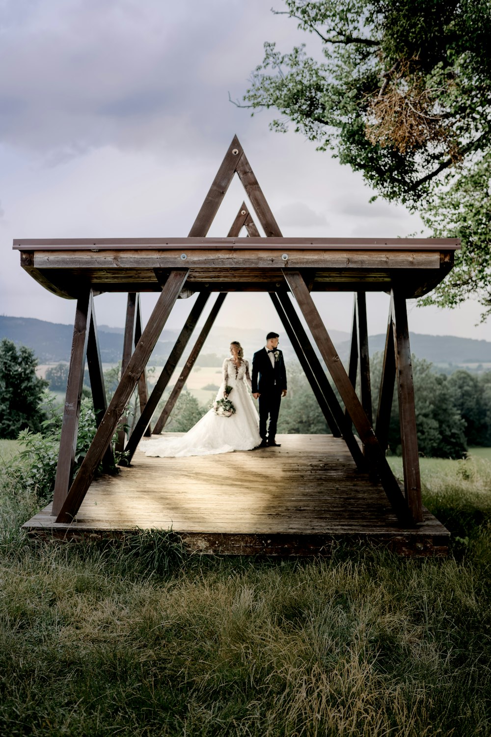 couple standing under brown wooden cross