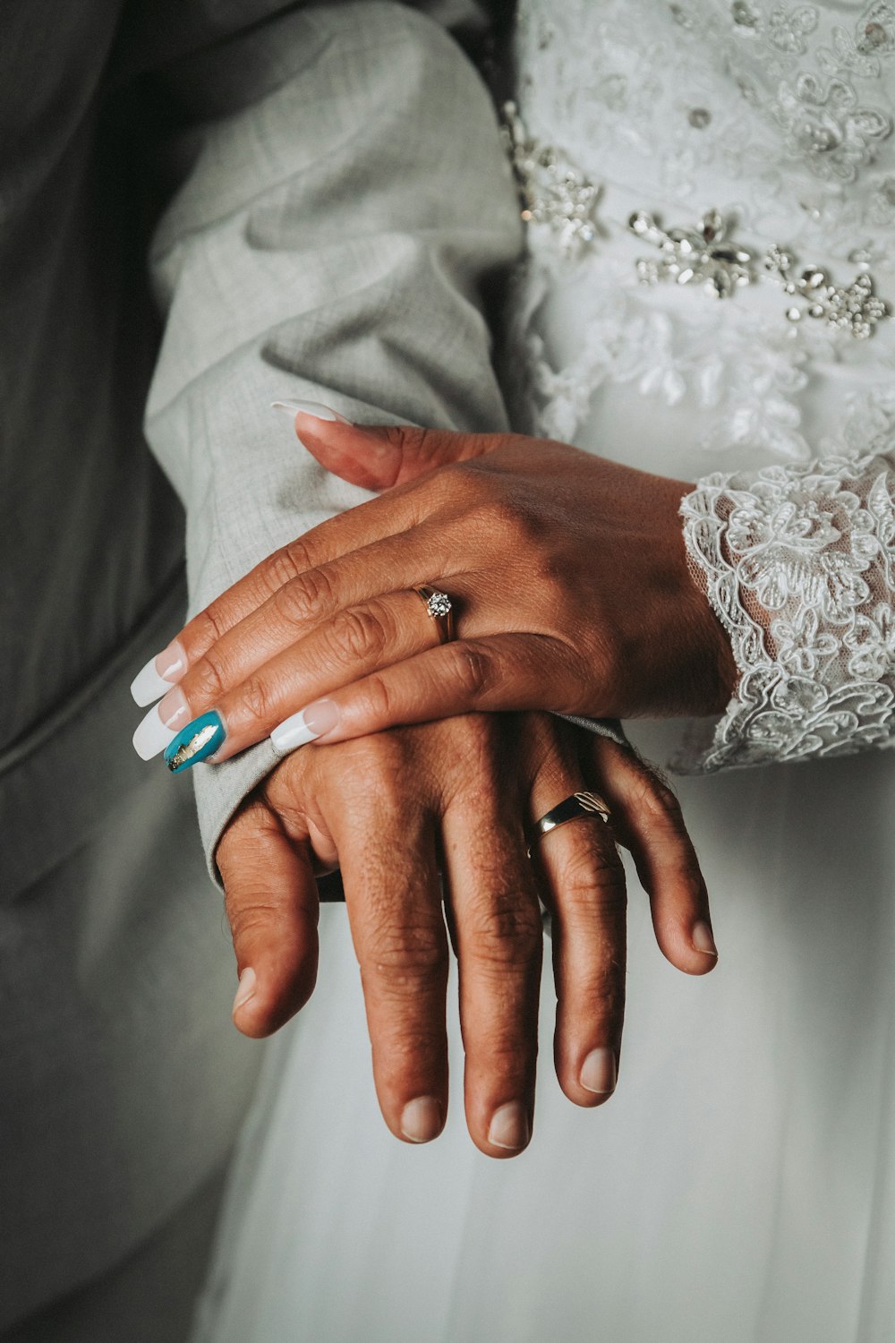 person wearing silver ring with blue manicure