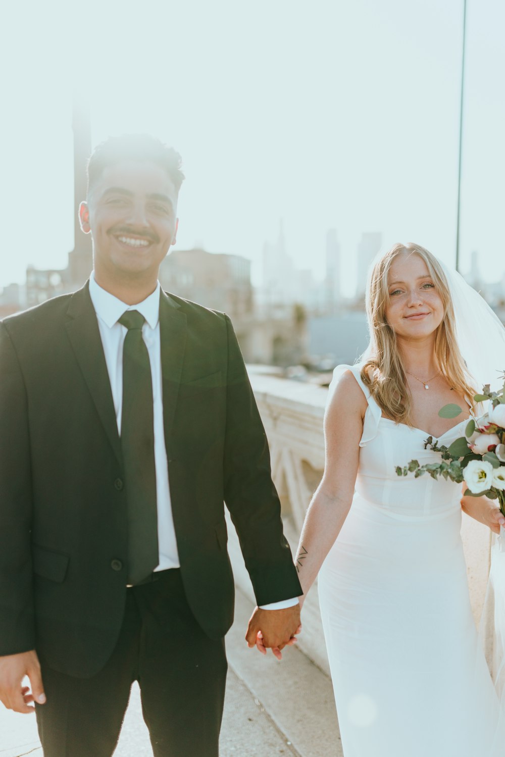 man in black suit jacket beside woman in white sleeveless dress