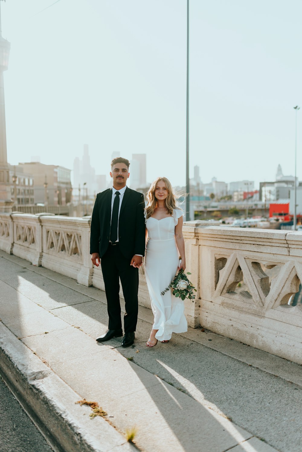 man in black suit standing beside woman in white wedding dress