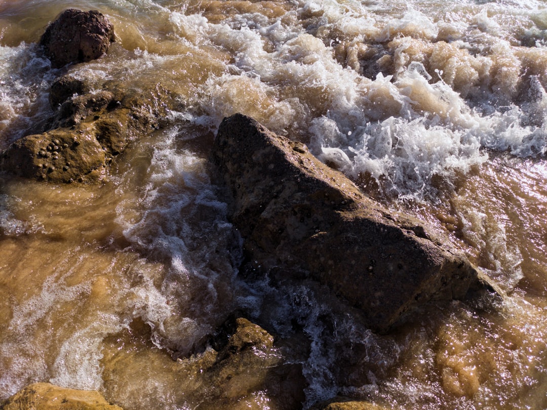 water waves hitting brown rocks