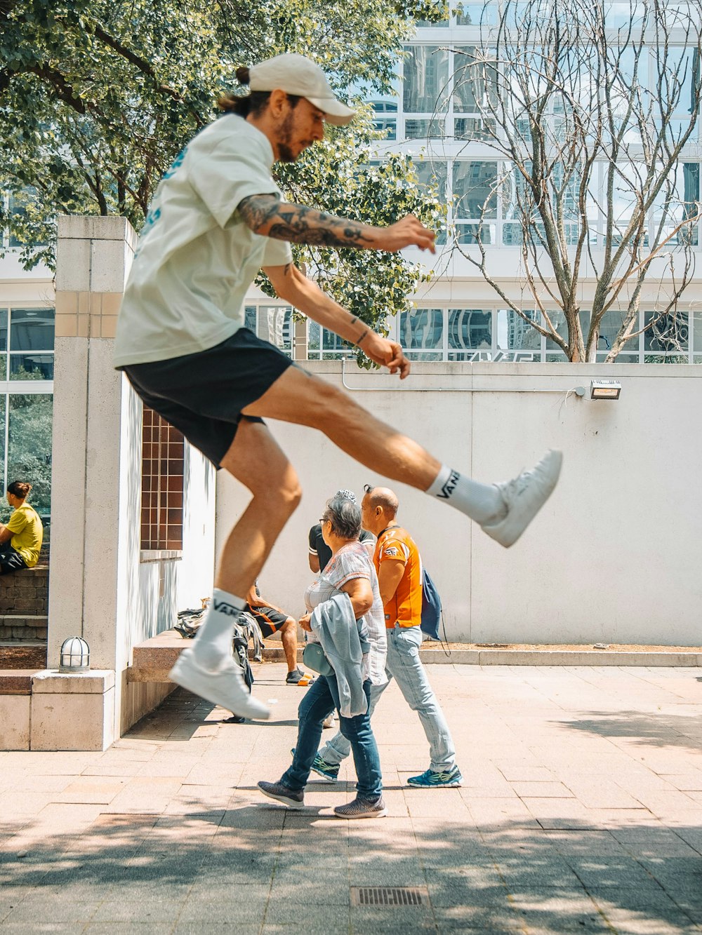 man in white shirt and blue denim jeans jumping on air