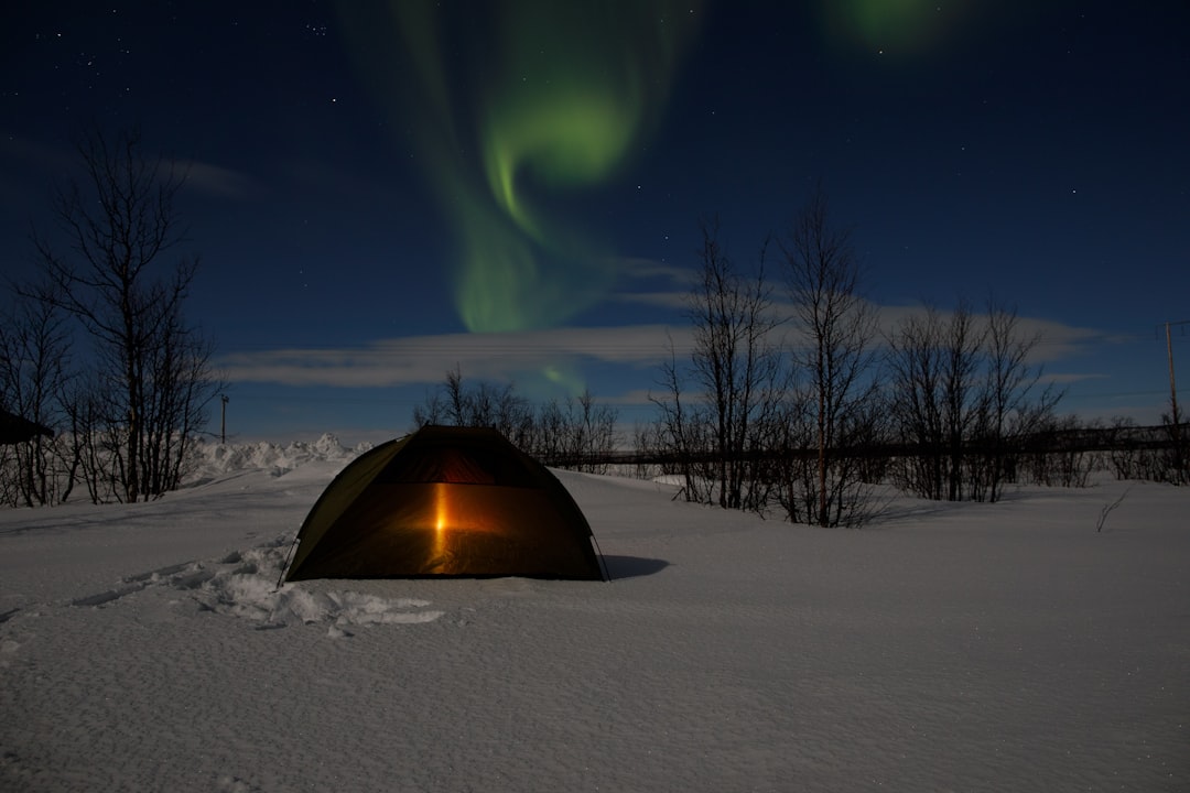 brown tent on snow covered ground under blue sky during night time