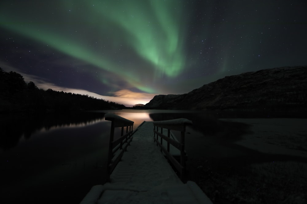 brown wooden dock under green sky