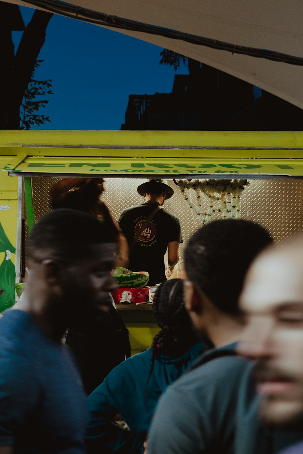 people standing near green bus during night time