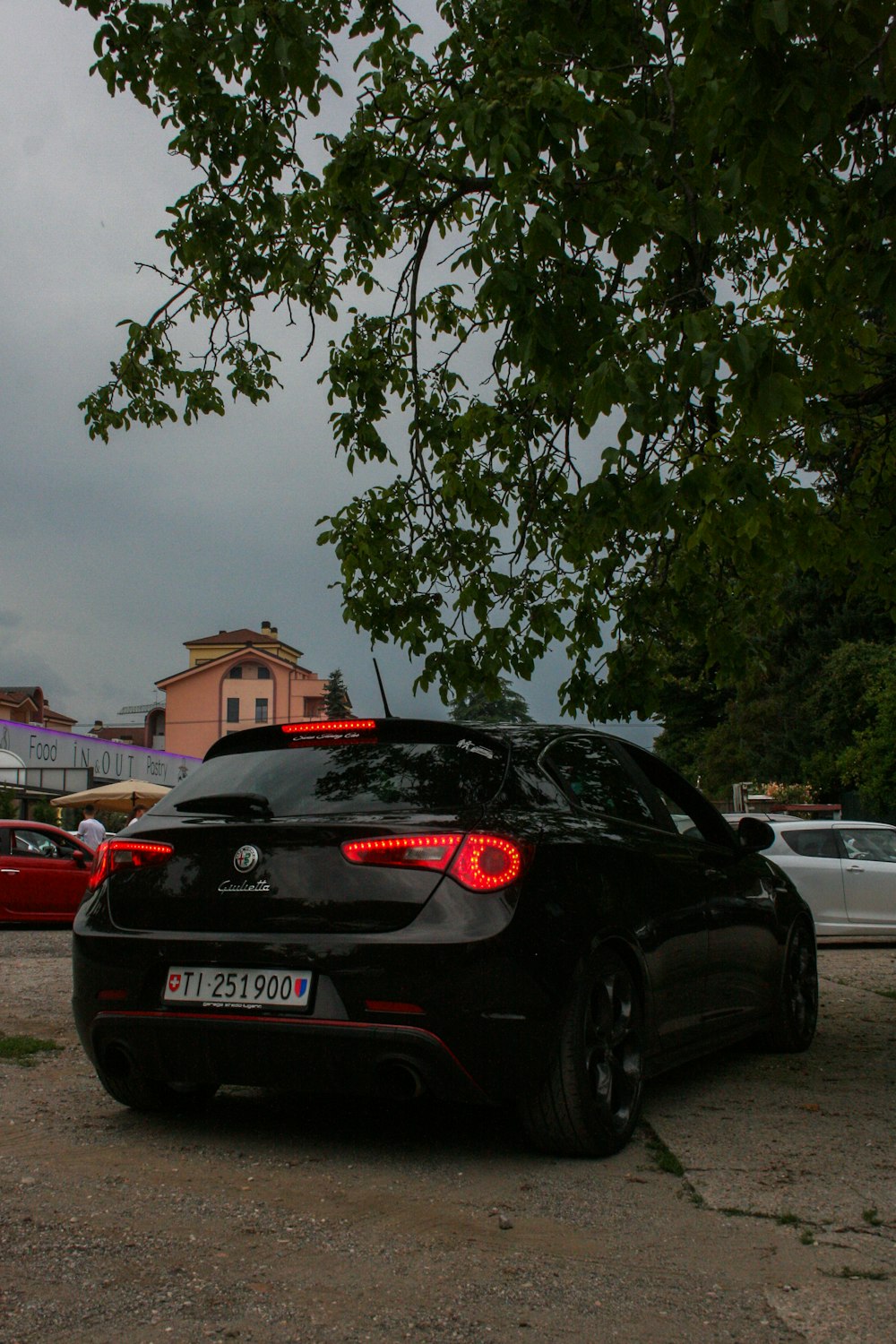 black honda car parked near green tree during daytime