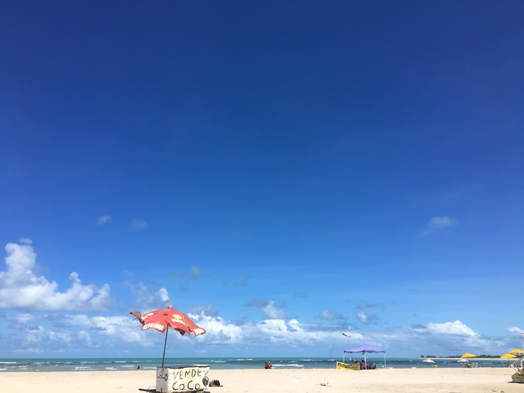 red umbrella on beach during daytime