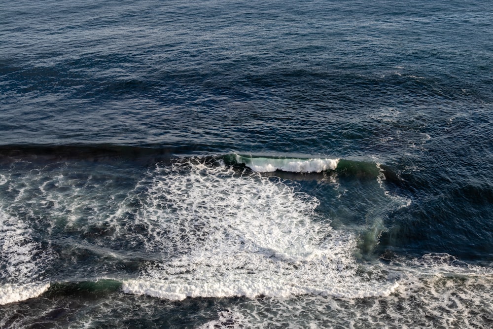 ocean waves crashing on shore during daytime