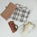 A flat lay of modest clothing items including a vest, inner top, and loose pants on a neutral background.