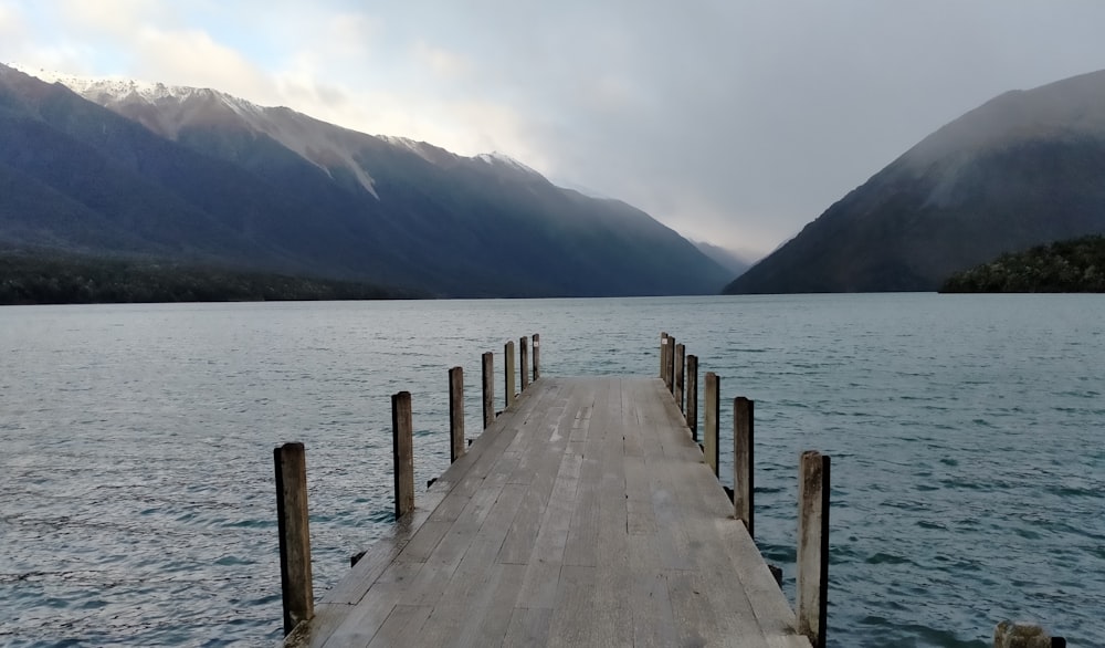 brown wooden dock on lake during daytime