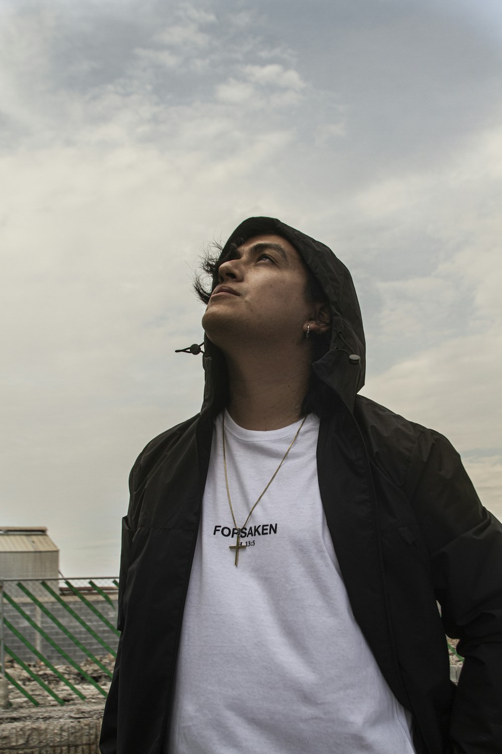 a man standing in front of a building with a cigarette in his mouth