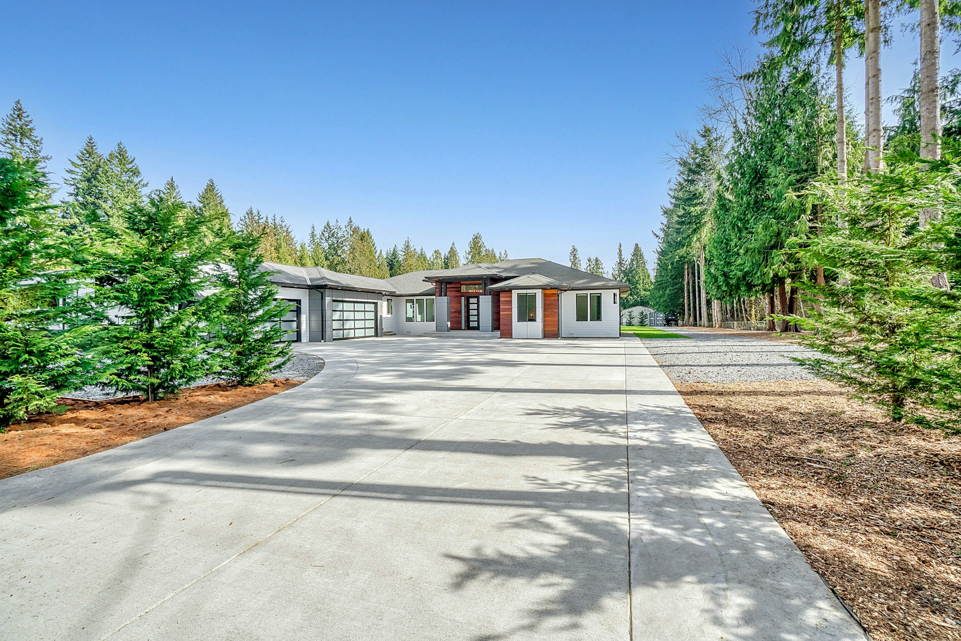 white concrete house near green trees under blue sky during daytime