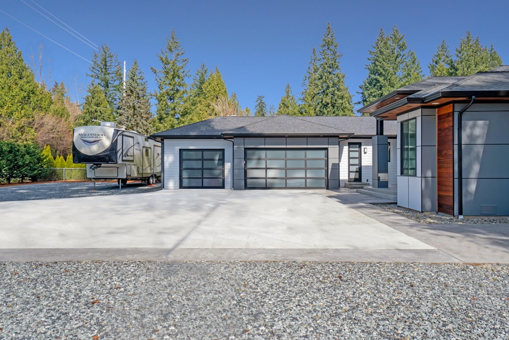 white and gray wooden house near green trees during daytime