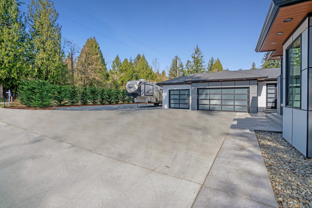 white and gray house near green trees under blue sky during daytime