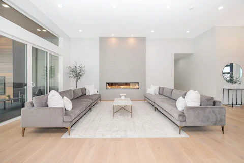 Two grey velvet sofas facing each other in a bright modern living room