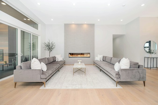 Two grey velvet sofas face each other in a bright, modern luxury living room