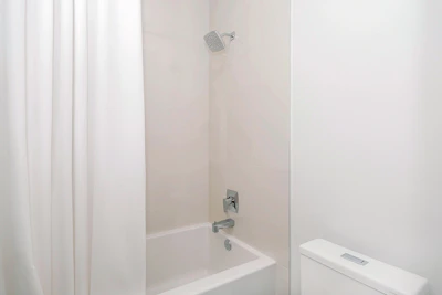 Bathroom showcasing a hot shower with minimalist fixtures and bright, airy space.