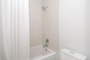 A neatly hung shower liner with subtle patterns in a bright, clean bathroom.
