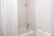 Bright, modern bathroom with a minimalist shower and clean white tiles, showcasing a fresh renovation.