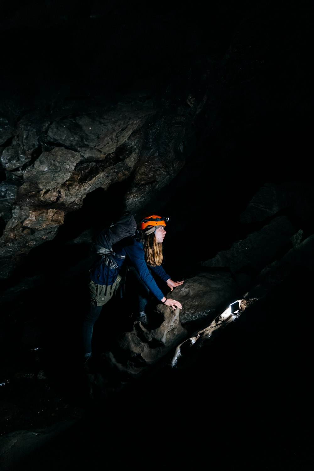 Mann in blauer Jacke und blauer Jeans auf Felsen stehend