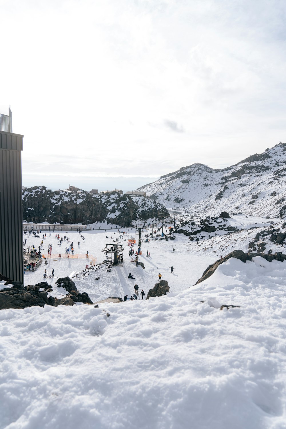 昼間、山の近くの雪道を歩く人々